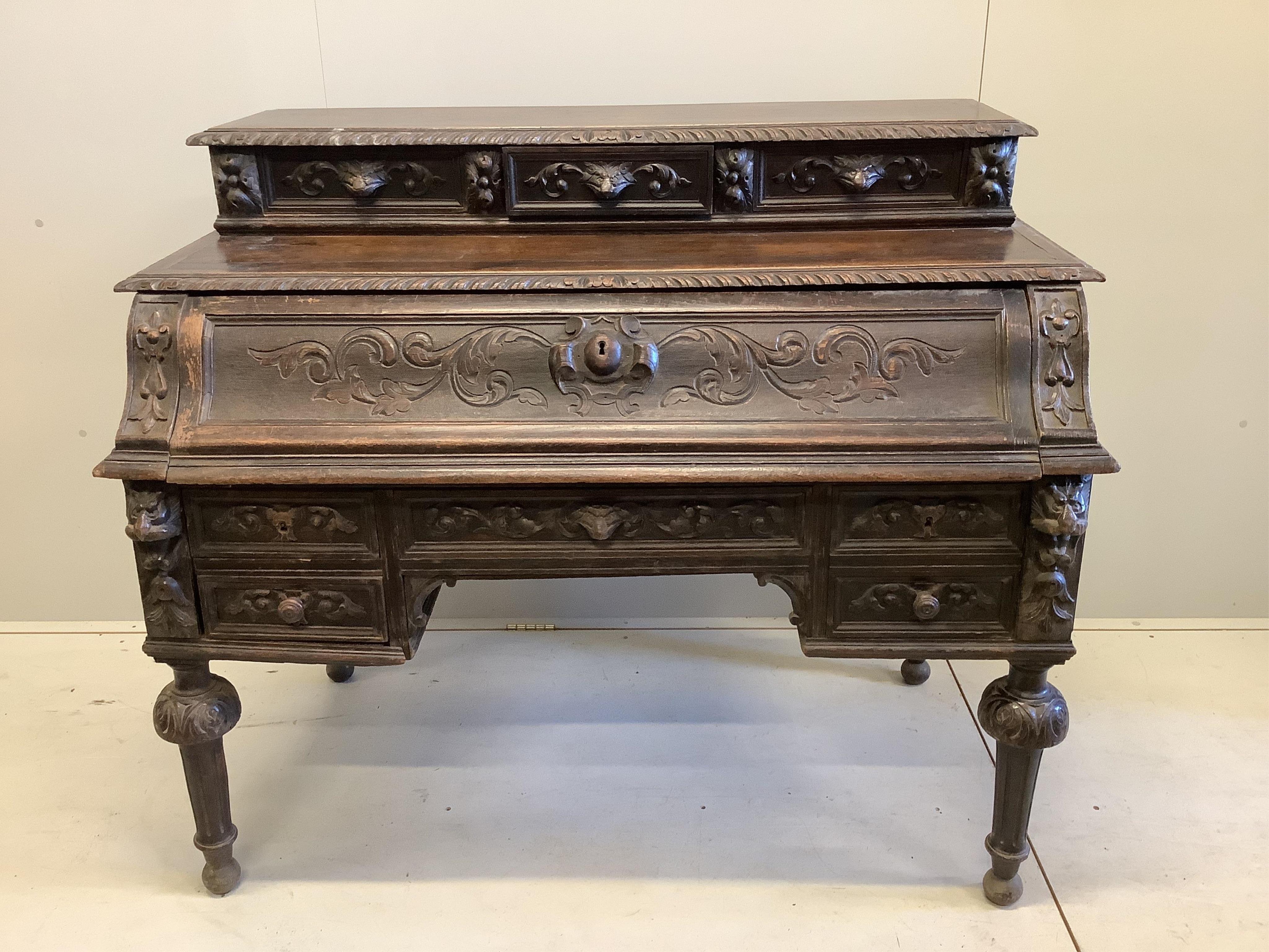 A late 19th century Flemish carved oak secretaire kneehole desk, width 129cm, depth 71cm, height 111cm. Condition - fair